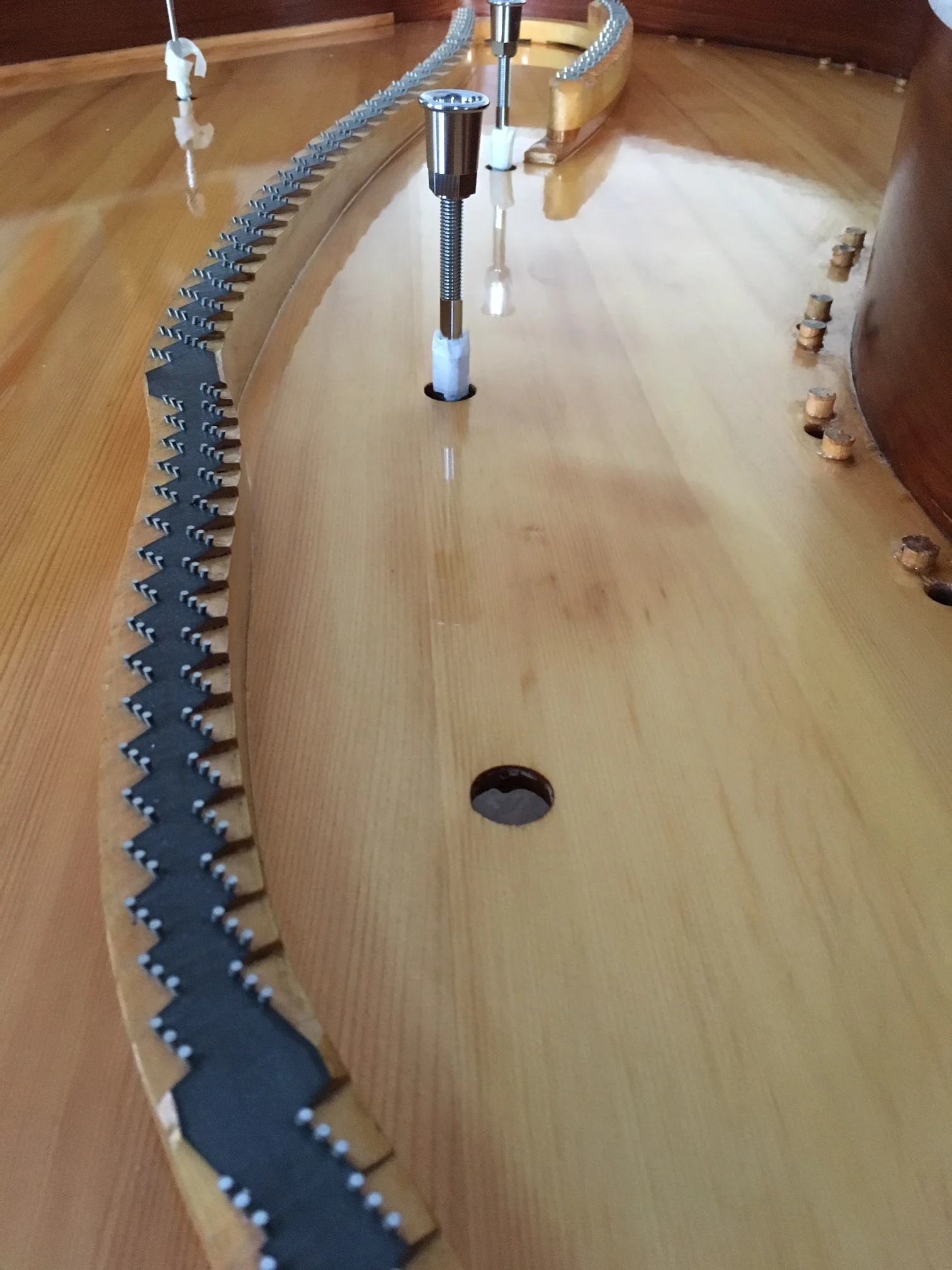 Soundboard varnish cut back with progressively finer grades of wet n' dry paper and then further cut-in with 3 grades of burnishing and polishing creams to give a beautiful flat, smooth and shiny finish