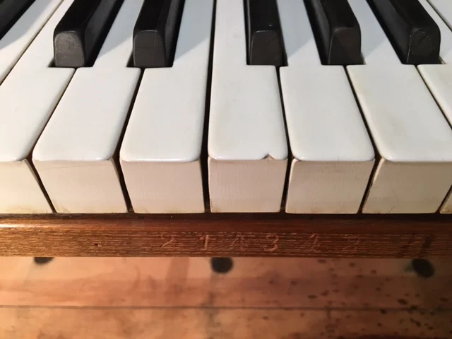 The old, chipped and worn ivories, prior to new key coverings including new solid ebony sharps