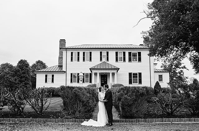 black and white film shot of couple in front of house