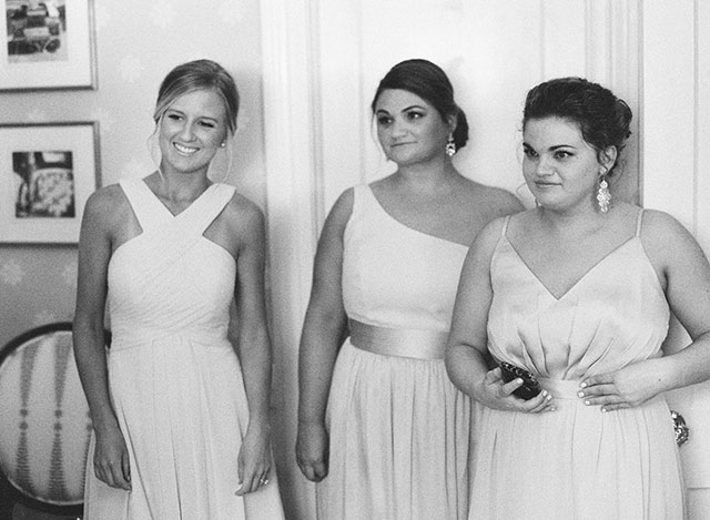 bridesmaids watching as bride buttons dress