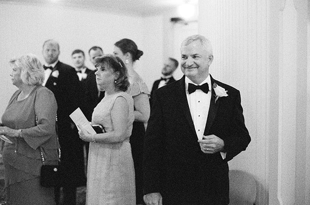 father of the bride smiles as he waits for the ceremony to begin