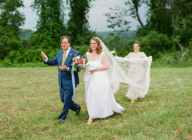 bride cries as her father walks her down the aisle