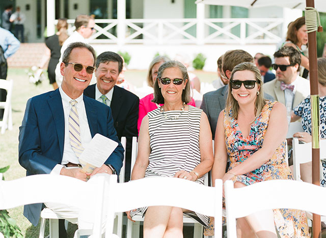 Guests wearing sunglasses and sitting outdoors, enjoying the sunshine