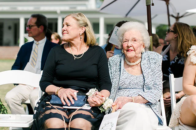 Bride and grandmother hold hands by Sarah Der