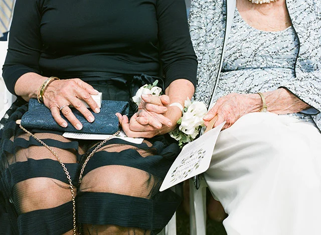 Sincere wedding photography, grandmother and mother hold hands by Sarah Der