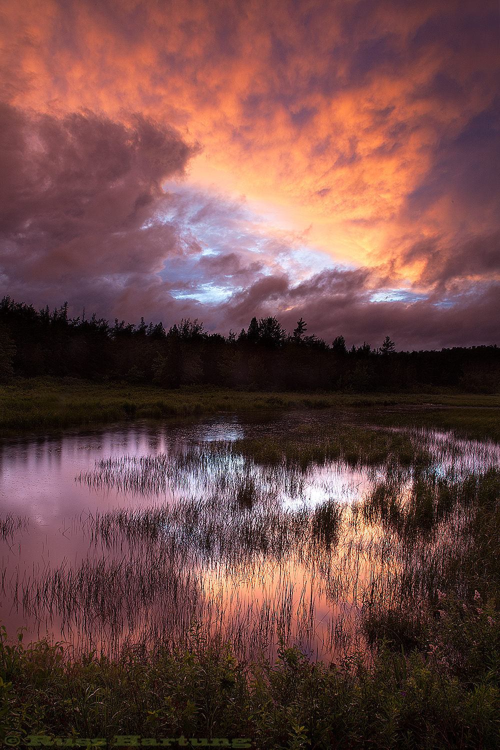 Clearing thunderstorm at sunset near Saranac Lake. It was still raining where I stood and the lightning was still active but as the sun set, the clouds broke up in the western sky. 