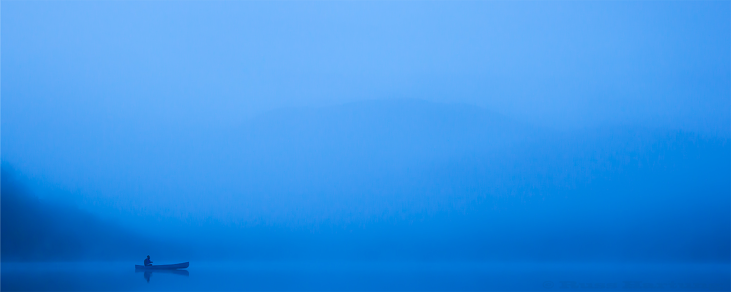 "Solitude" - Before sunrise a lone canoeist glides across Heart Lake in the High Peaks region of the Adirondacks. He was moving so slowly through the mist that he didn't even create a wake.