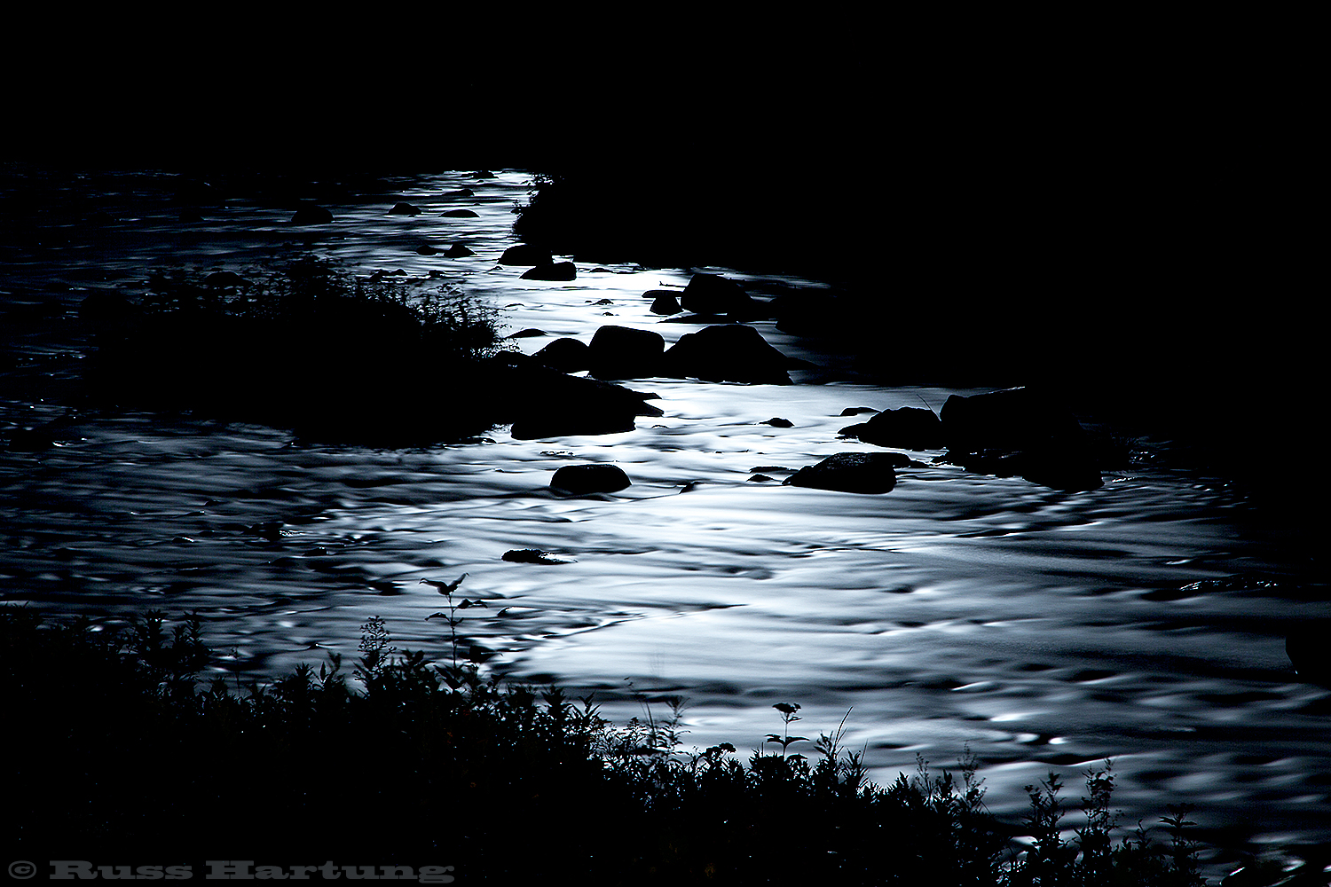 The Saranac River under the moonlight. A long, 3-minute exposure made the rapids look like molten silver.  