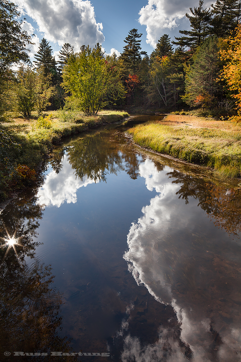 I love the way the clouds frame the reflection in this creek near Lower Saranac Lake. The sun provides an exclamation point. 