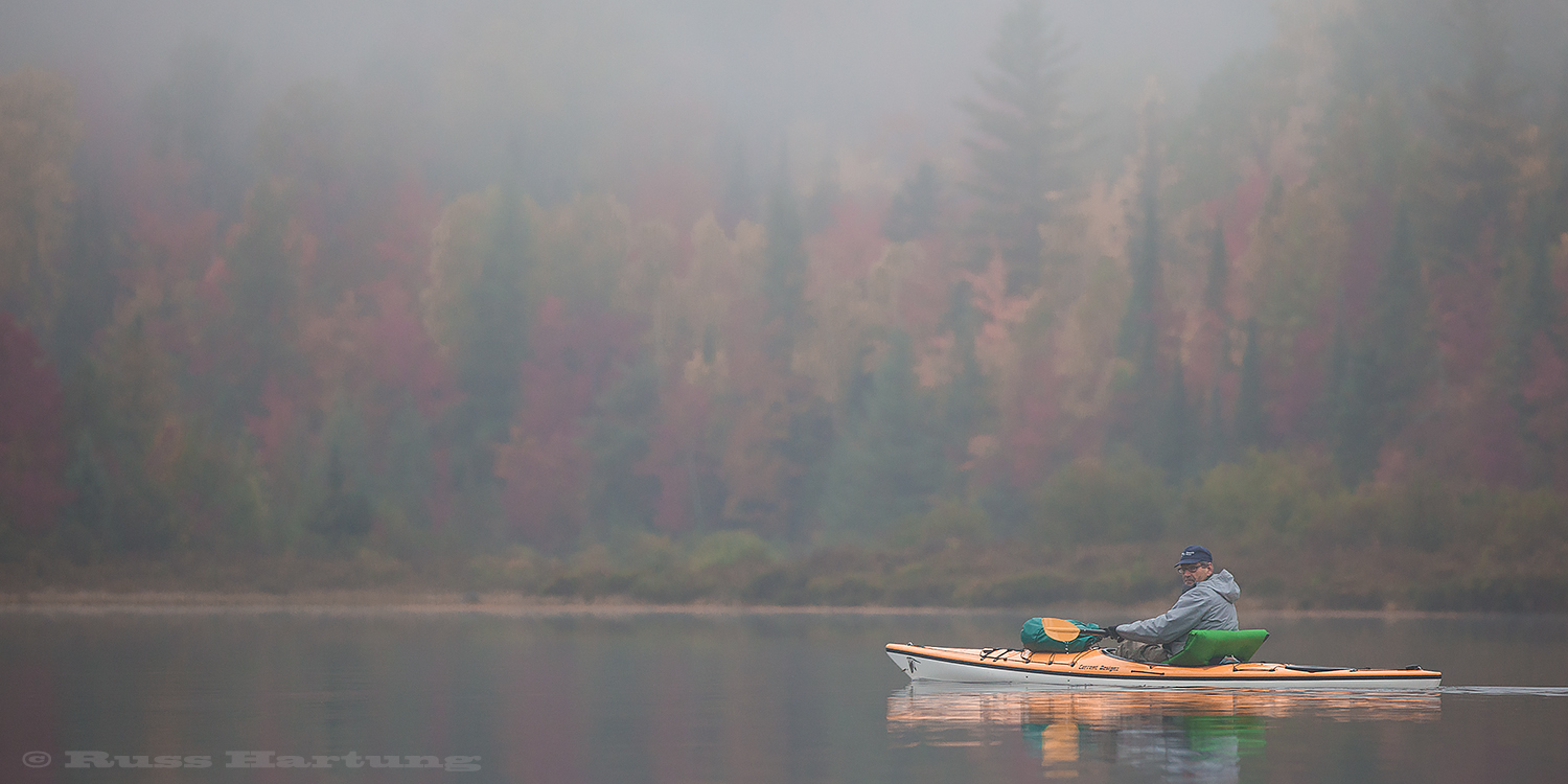 Paddling across a foggy Cheney Pond during peak foliage season. 