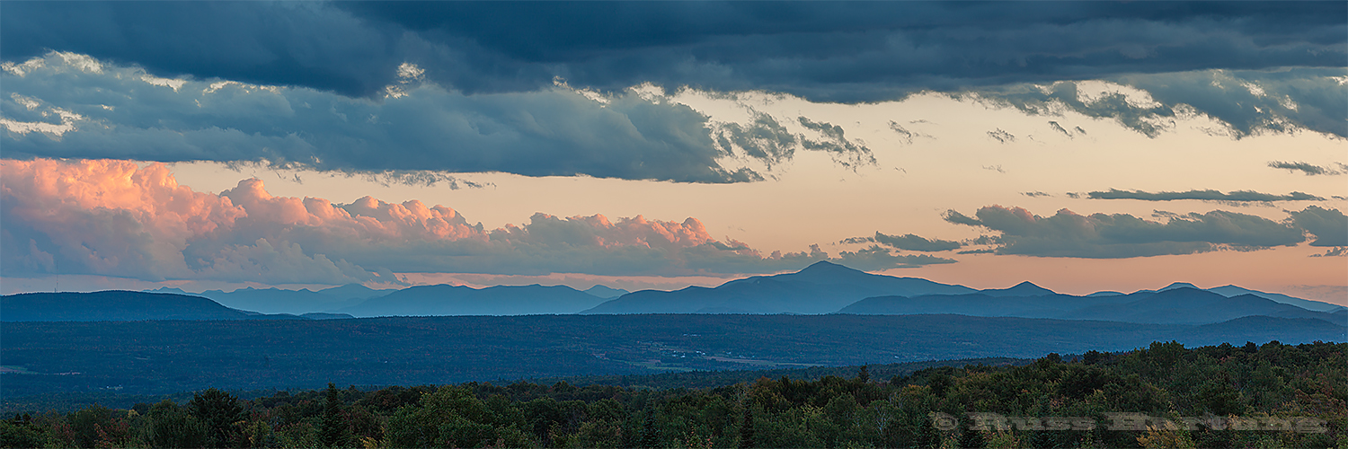 The last rays of the sun light up some clouds over the High Peaks. 