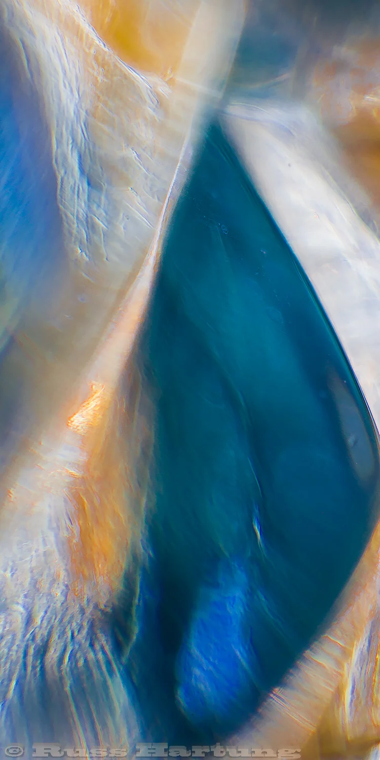 An extreme macro close-up of cut glass reflecting colored paper.