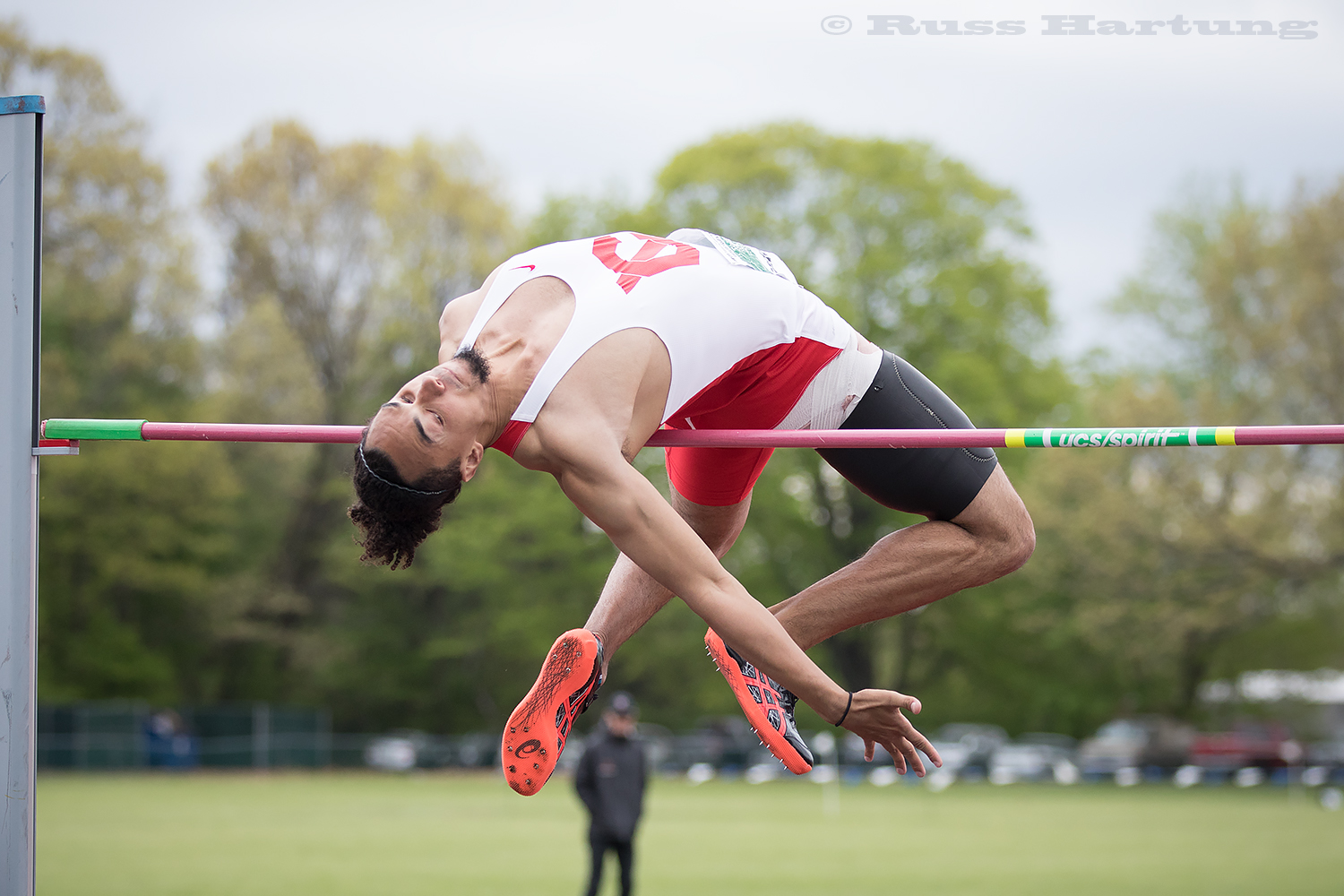A high jumper near folds himself in half to clear the bar. 