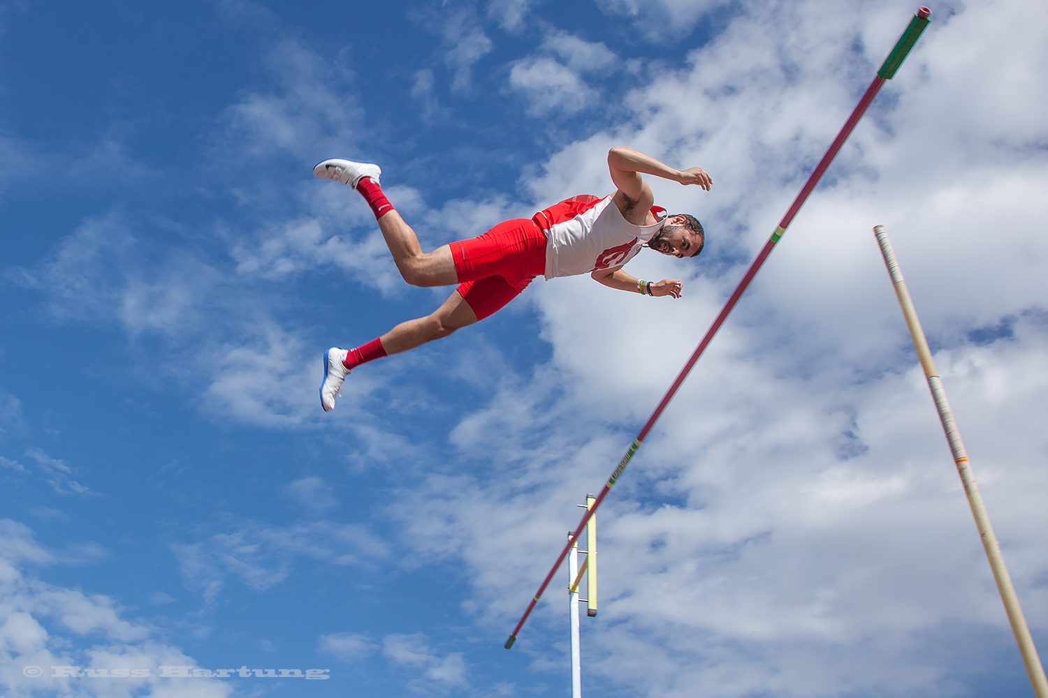 A pole vaulter seems suspended in air. 