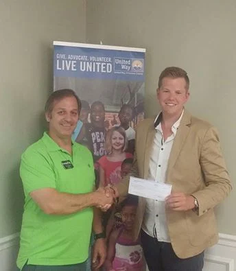 Brian Vinciguerra owner of Cracked It! Escape Games presents a check for the Onslow County Stuff the Buss Campaign. The Escape Room dedicates 10% of it's Monday and Thursday proceeds to local charities via it's #GIVEBACK initiative.