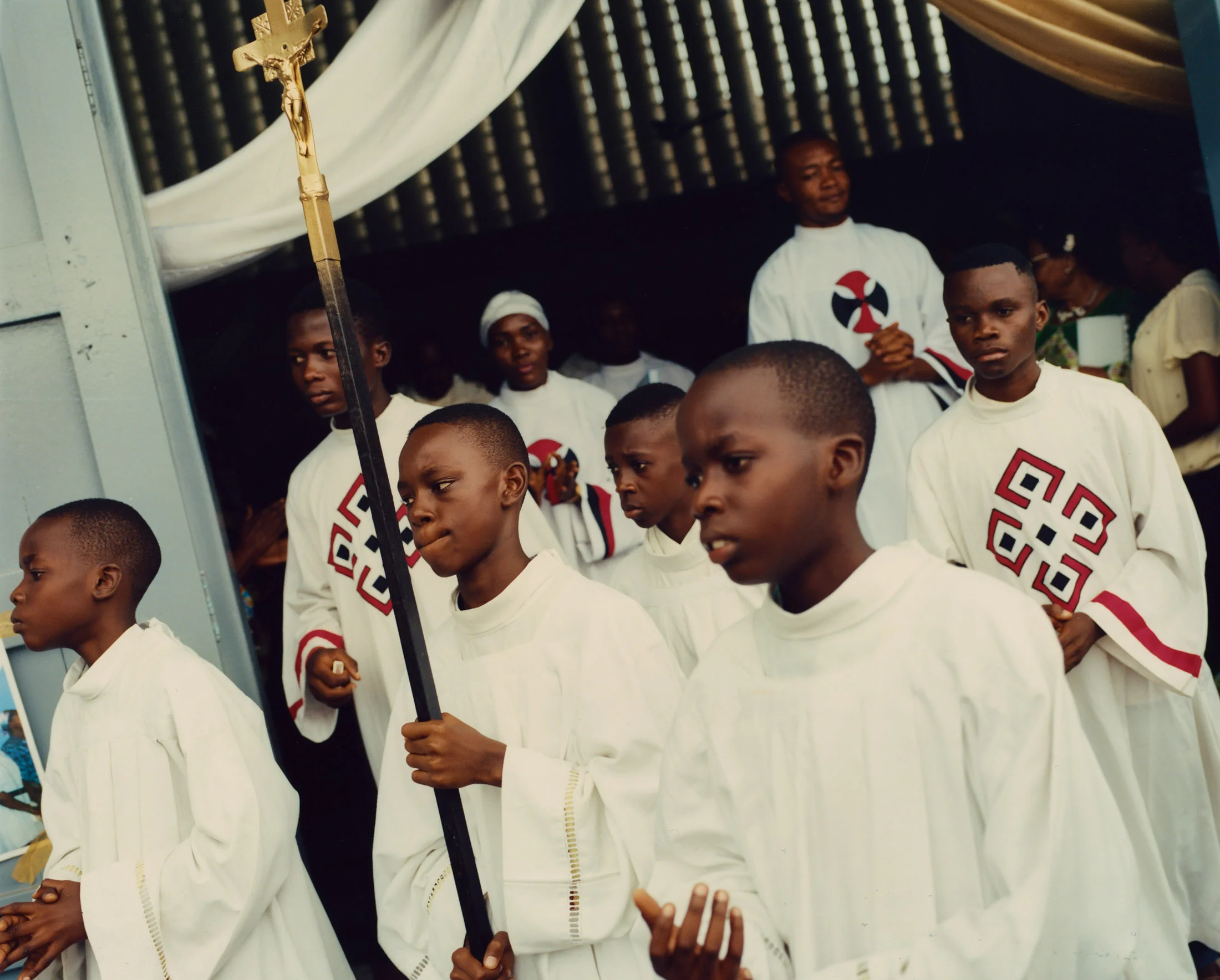 Between Sunday services, the acolytes of Saint Dominique walk the parish grounds. Limete, Kinshasa.