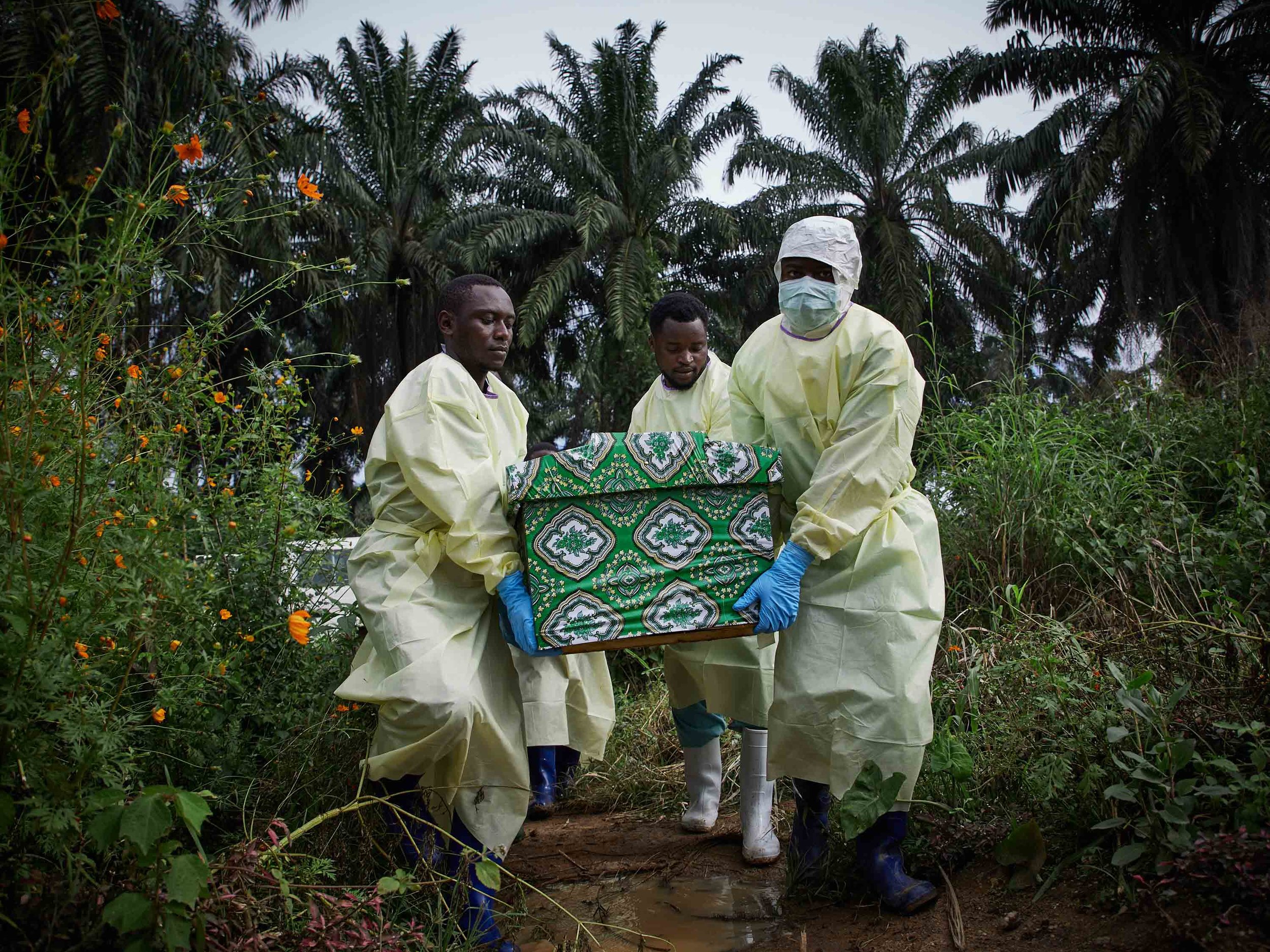  Health workers carry the coffin of Kakule Mbusa Désiré, an Ebola victim, at Ngongolio cemetery, North Kivu. 