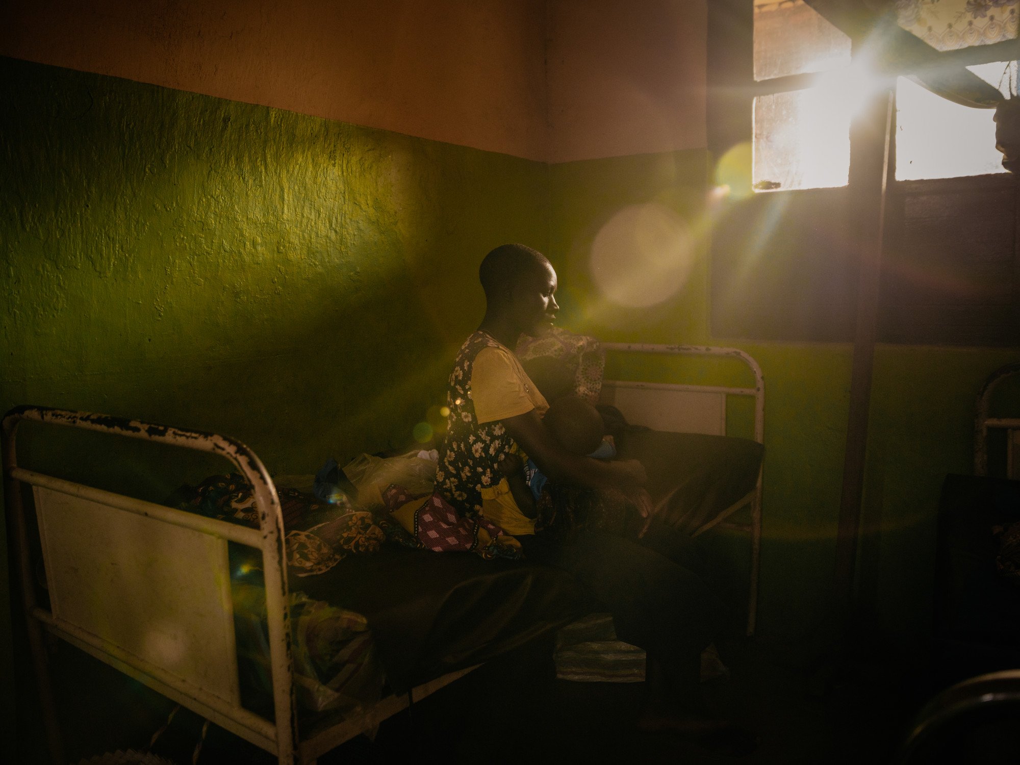  Mave Bora sits with her injured child after a CODECO rebel raid on a displacement camp in Ituri. 