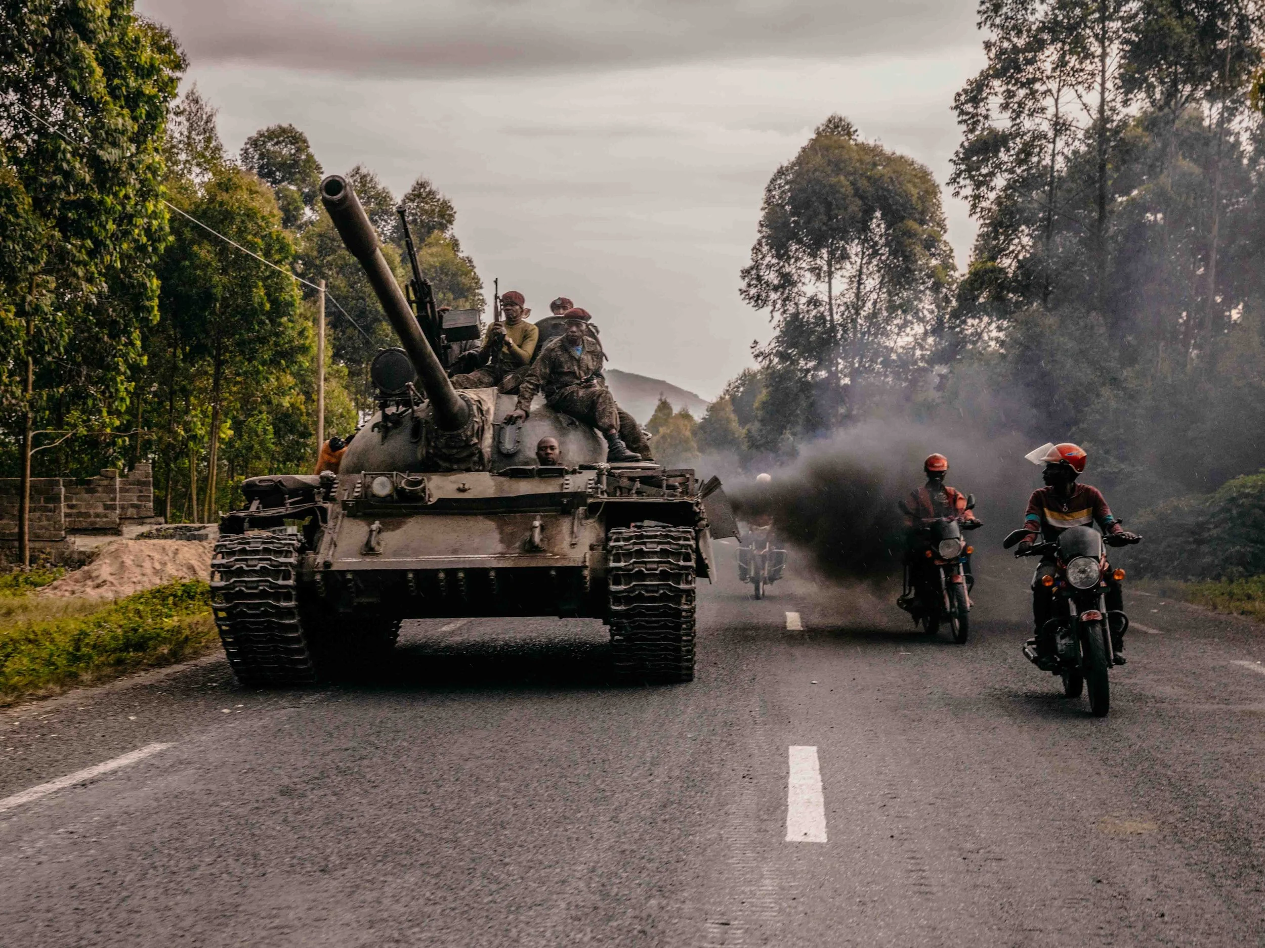 Congolese Army tank units rush to counterattack an M23 rebel offensive in Kibumba as motorcycle taxi riders cheer them on.