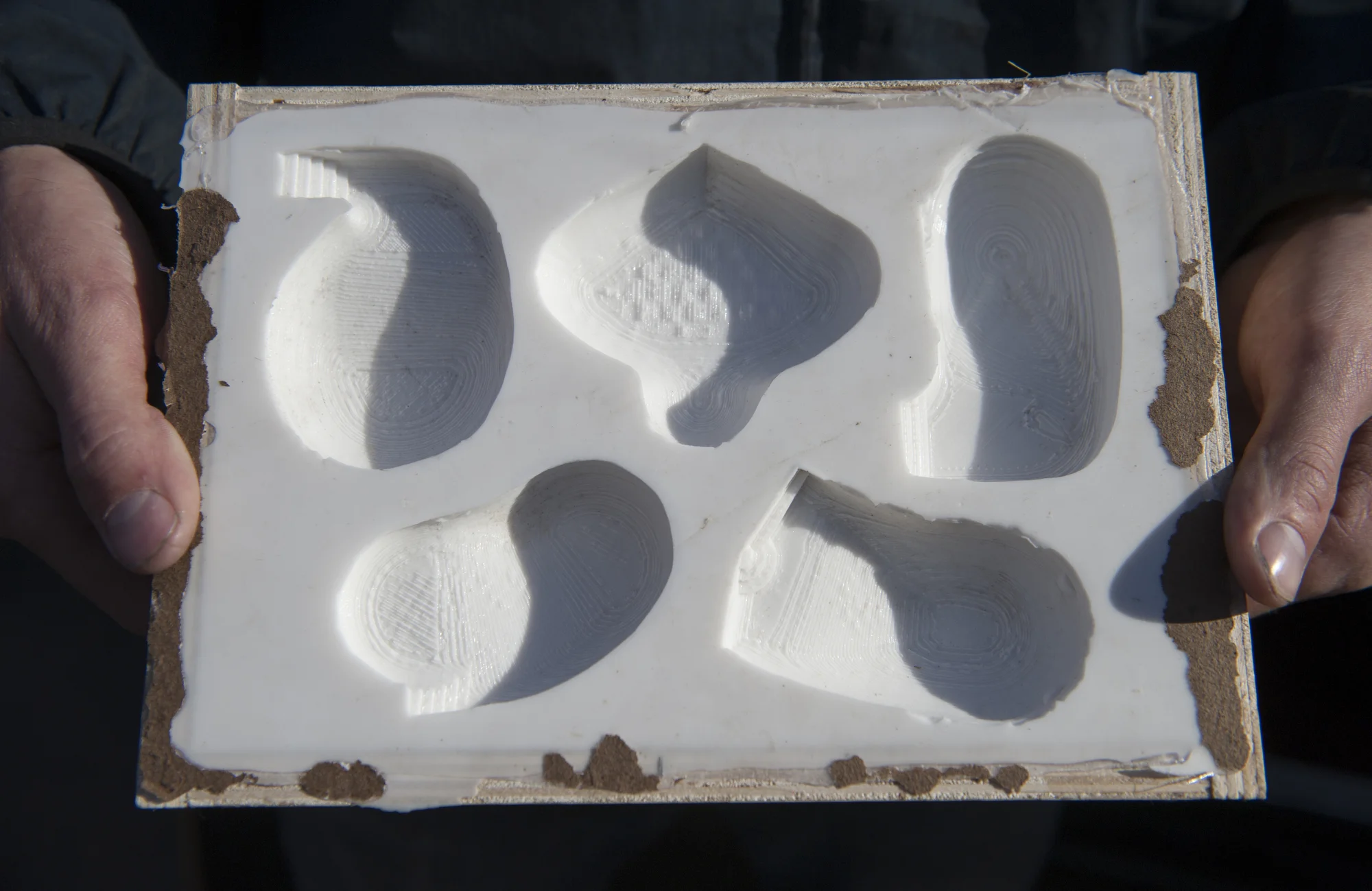 Tim Bearse holds his 3-D cast skate pool artwork. The middle and the bottom left are fantasy models, while the other are real pools in California. 