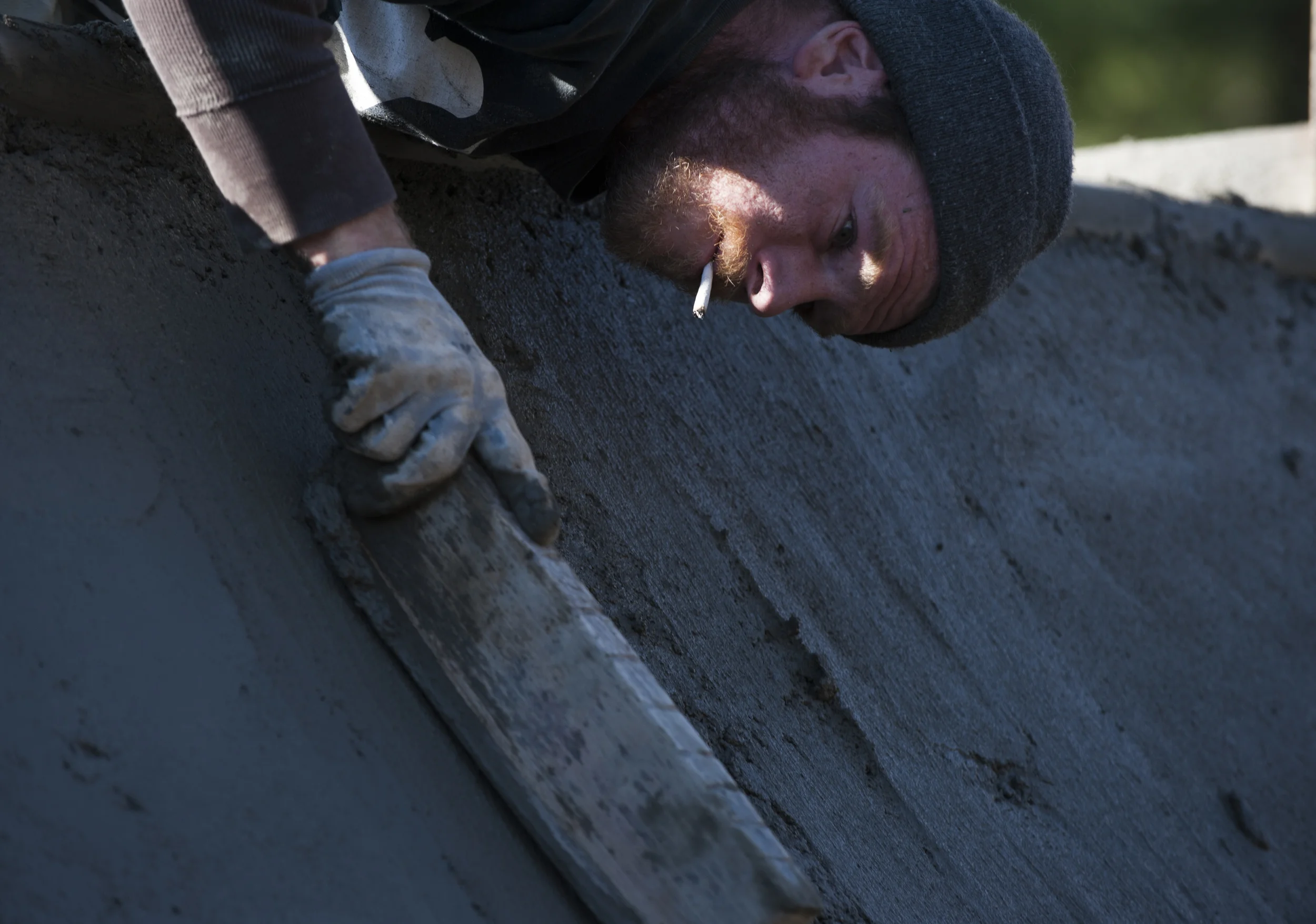 Zack Powell smooths out the concrete on one of the quarter pipes. Powell, a skateboarder, knows what to look for when finishing the concrete. 