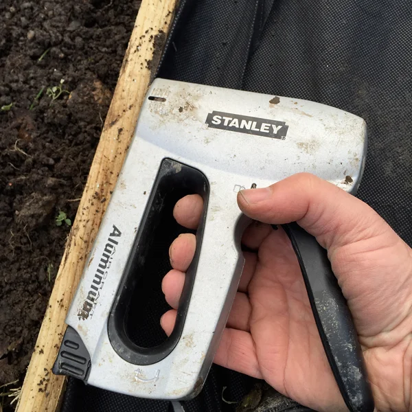 Stapling in the weed control fabric to the timber path edging. I’d’ve preferred thick black polythene as it’s a bit more rugged, but this was to hand and will do the job for now.