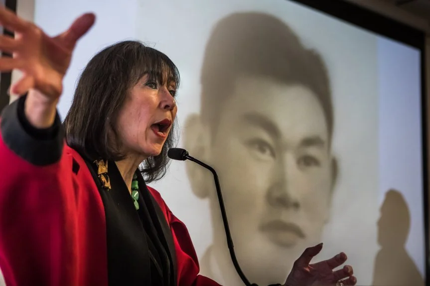 Karen Korematsu speaks to a crowd of about 100 about her father, Fred Korematsu and his struggle against the World War II-era racial profiling of Japanese American citizens and Japanese immigrants. His image is projected in background. The event was held at the Muslim community center the Pacifica Institute in Albany and featured a multicultural gathering of members of Jewish and Muslim groups in the Bay Area. Photo by Paul Kuroda