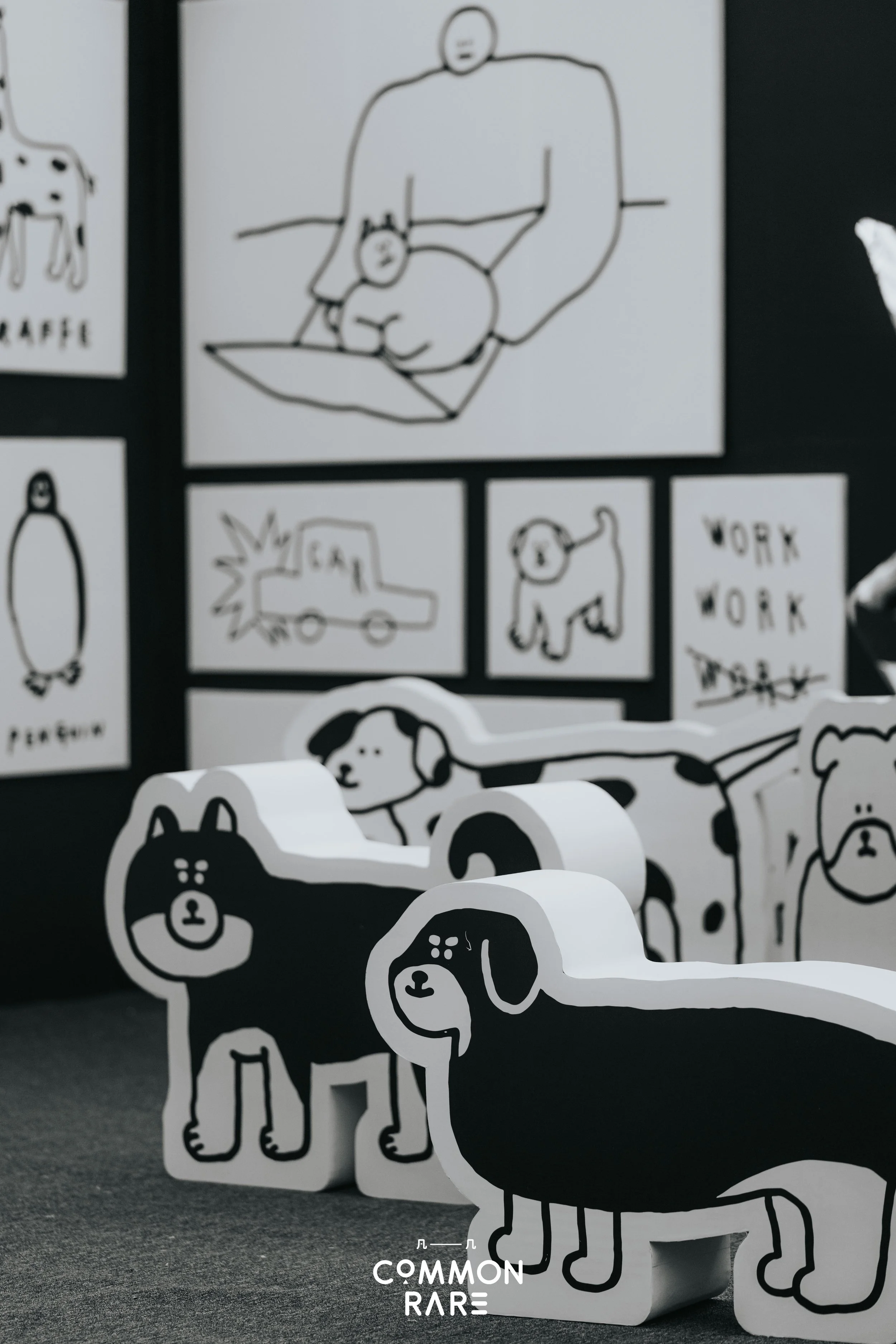 Black and white illustrated stickers of dogs, some standing and some lying down, arranged on a display board and a table.