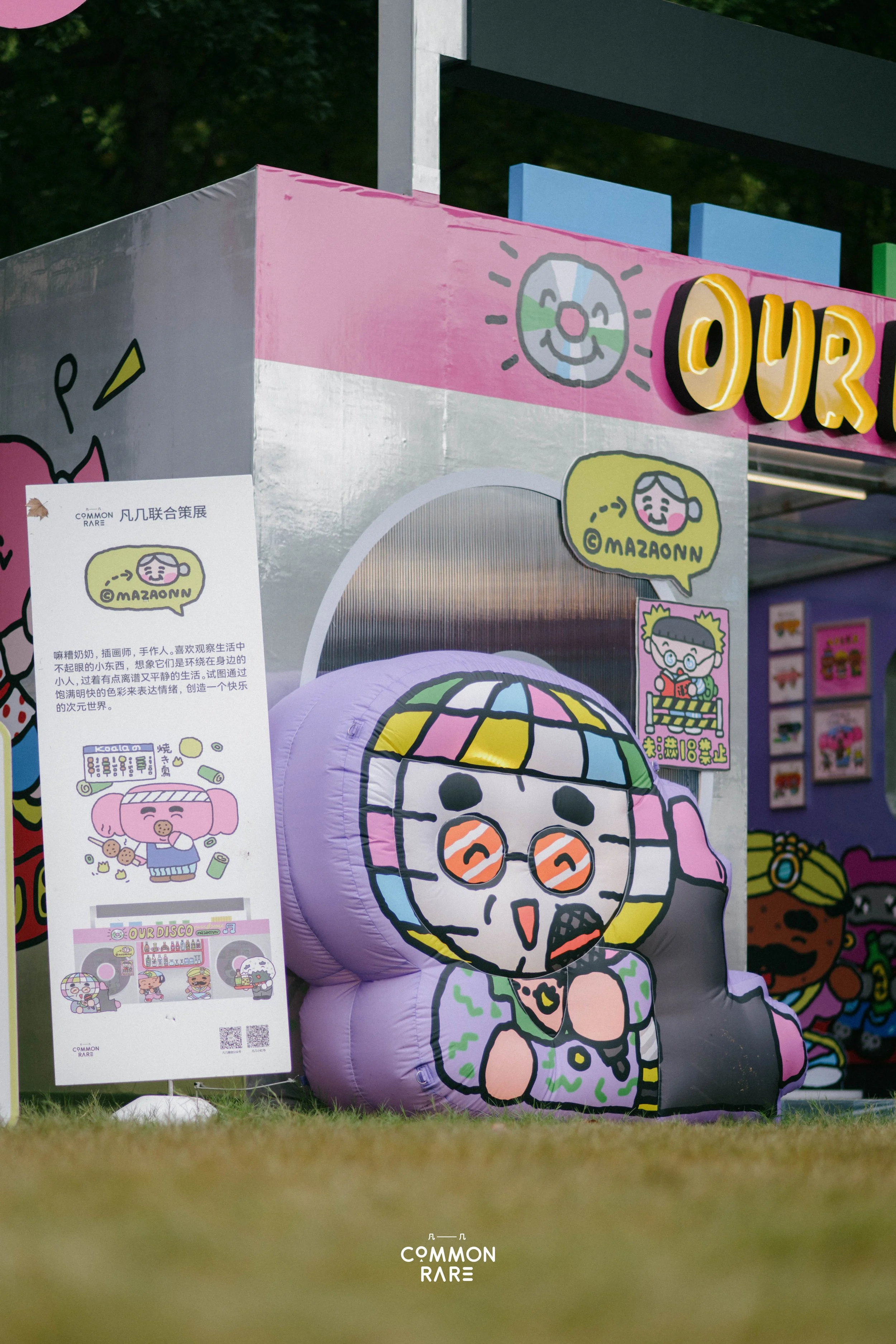 Colorful inflatable decorations with cartoon characters and posters at an outdoor event.