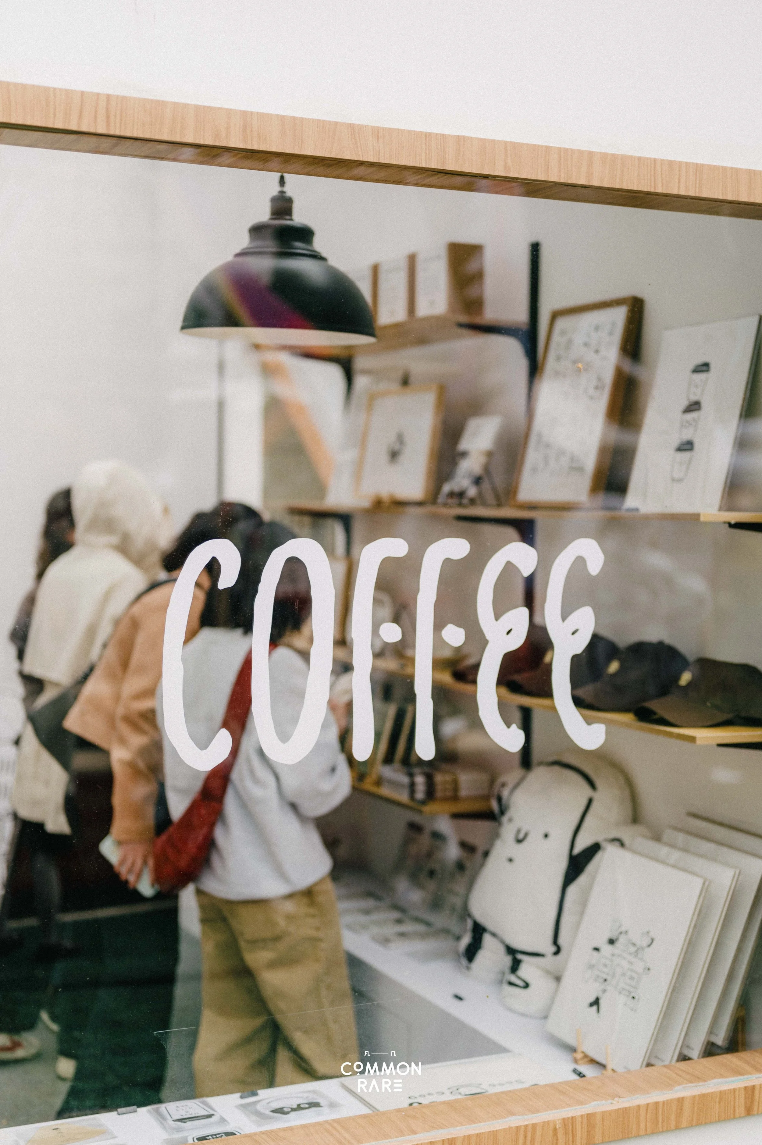 People shopping for artwork and home decor in a store window display.