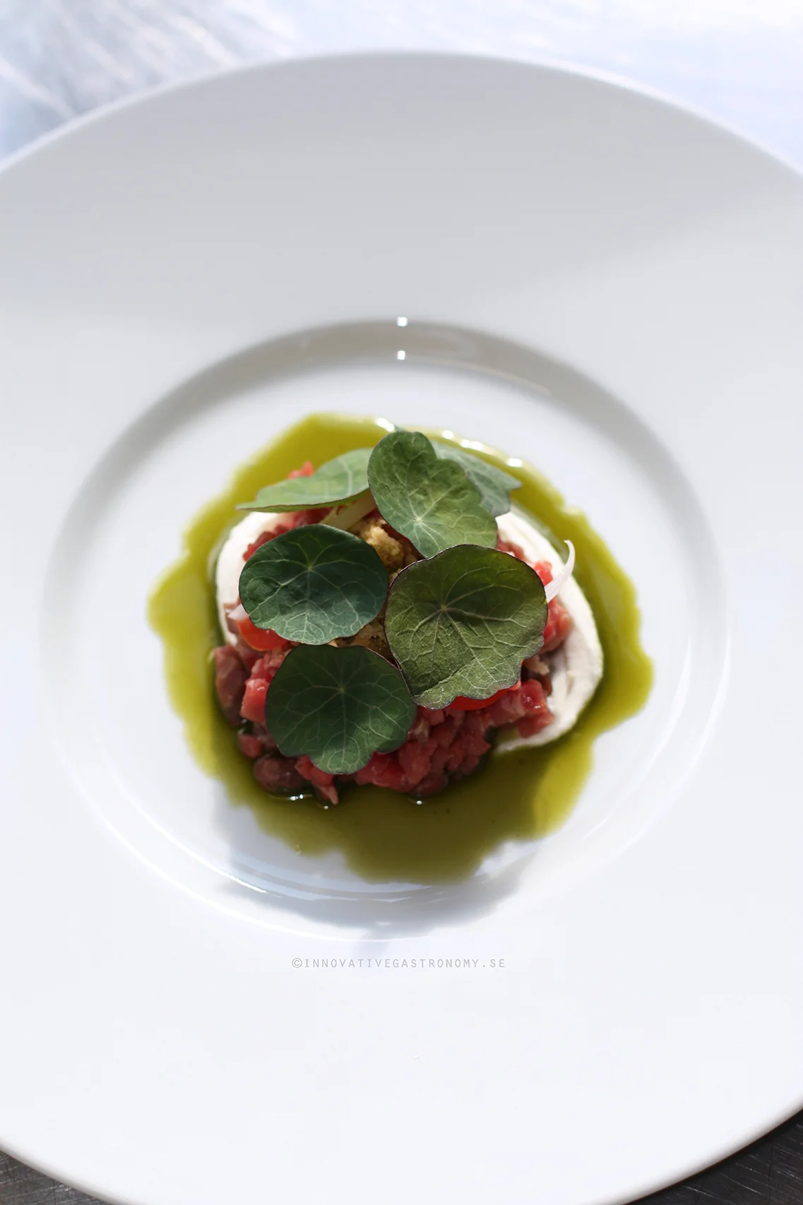 Tartar of dry aged beef, smoked cream cheese, fresh tomatoes, pickled schalotts and nasturtium