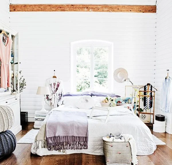 A slightly more modern twist to country living with splashes of colour, and the use of clothing as a feature in the room. Nordique loves the use of books to create a bed-side table (did you spot that!), and the poufs and blankets create a real hygge feel. Image source