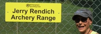 Judy Rendich with the sign Proclaiming the new name of the WSC archery range at Rodes farm, posted in 2018.
