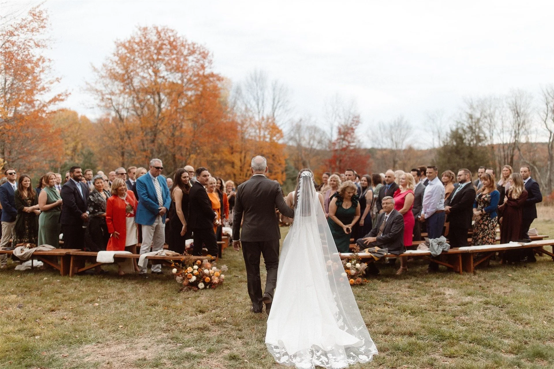 Outdoor-Ceremony-At-Hemlock-Neversink-New-York-With-Bride-And-Her-Dad-Walking-Down-The-Aisle-With-All-Of-Their-Guests-Surrounding-Them