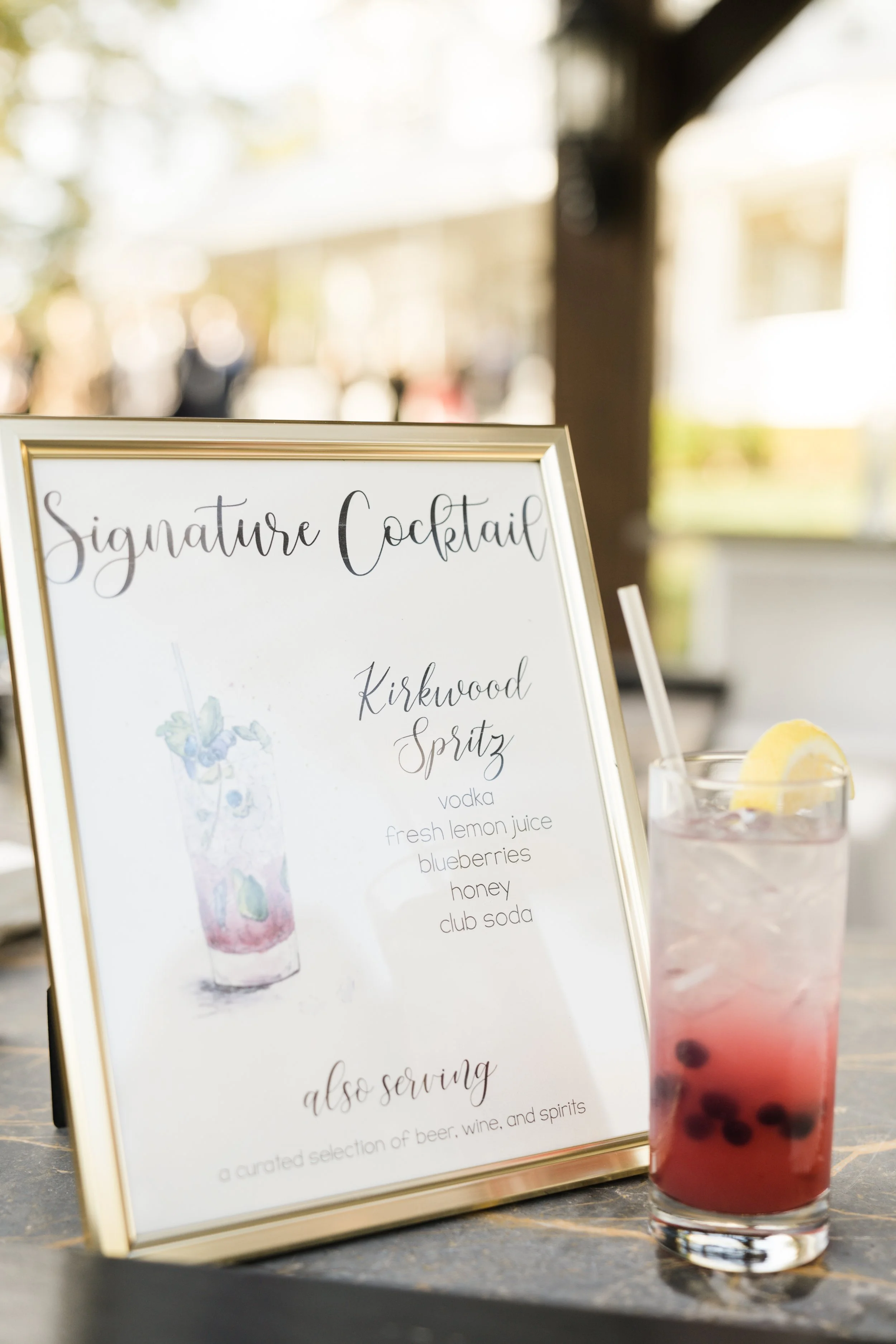 signature-drink-watercolor-sign-with-matching-drink-standing-next-to-it-for-outdoor-hudson-valley-wedd.jpg