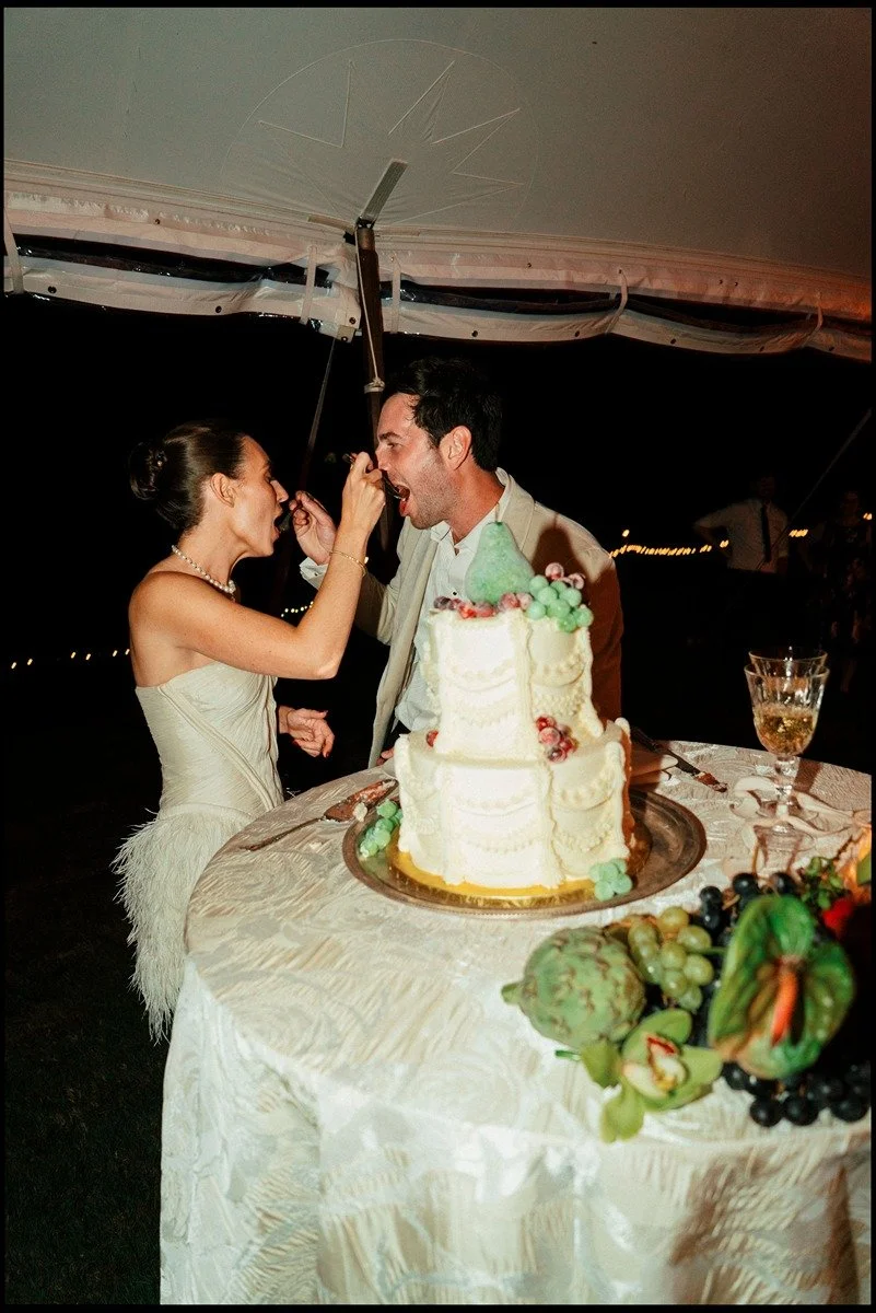 bride-and-groom-cutting-and-feeding-eachother-cake-at-their-hudson-valley-wedding-in-germantown-ny-taken-on-reel-film.jpg