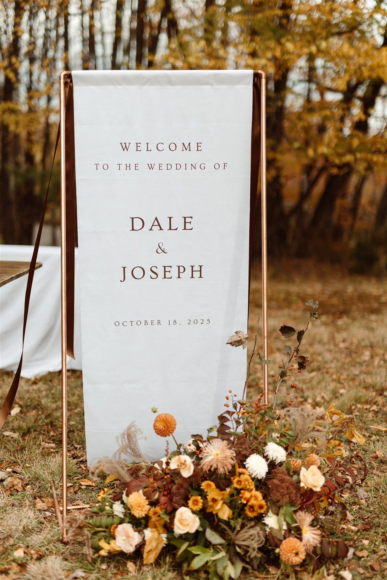 Fabric-Welcome-Sign-On-Gold-Stand-With-Burnt-Orange-And-Fall-Colored-Florals-Hemlock-Neversink-Wedding
