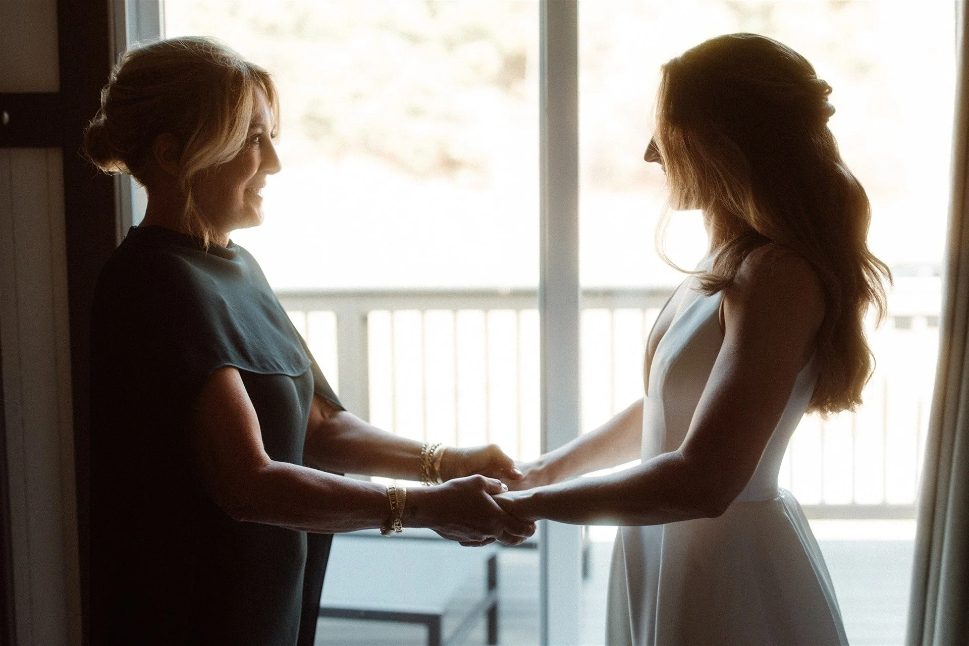 Mom-And-Her-Daughter-Holding-Hands-And-Talking-Before-First-Look-On-Daughters-Wedding-Day