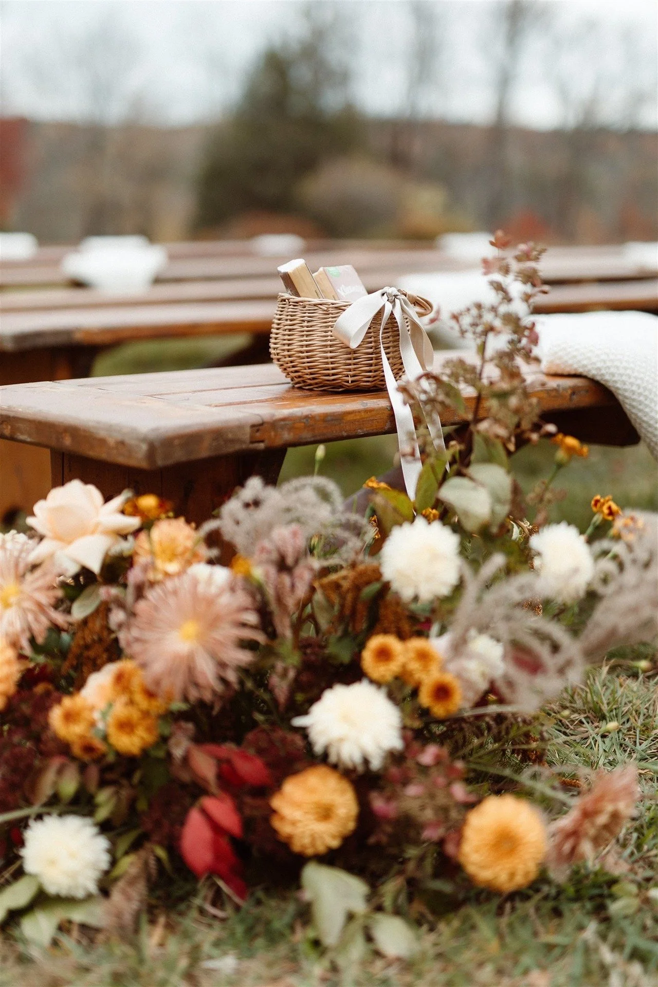 Close-Up-Of-Autumn-Flowers-At-The-Head-Of-The-Aisle-At-The-Ceremony-With-Benches-And-Flower-Girl-Basket-Waiting-For-Flower-Girl-To-Come
