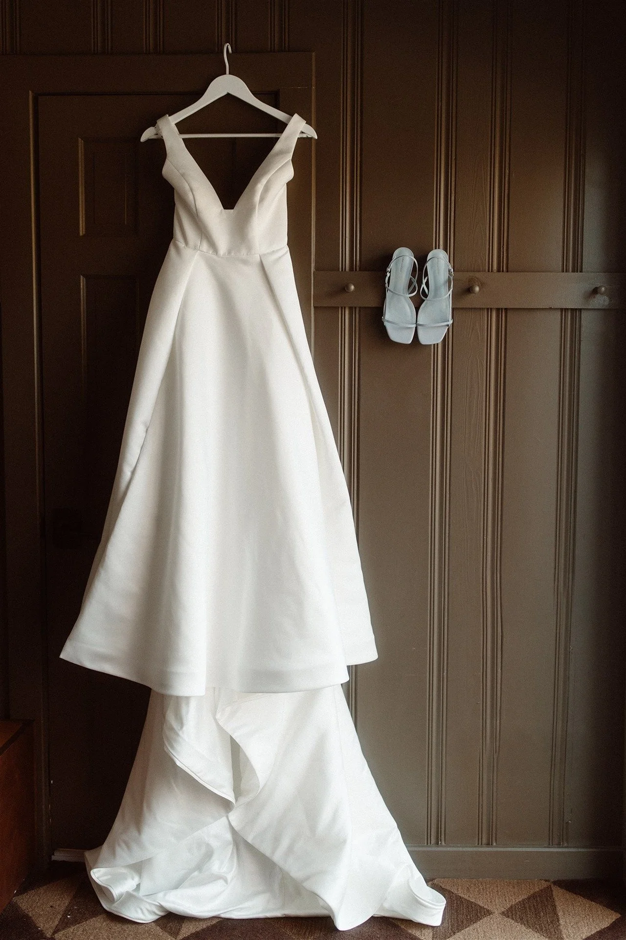 Bridal-Gown-Hanging-With-Wedding-Shoes-Detail-Shot