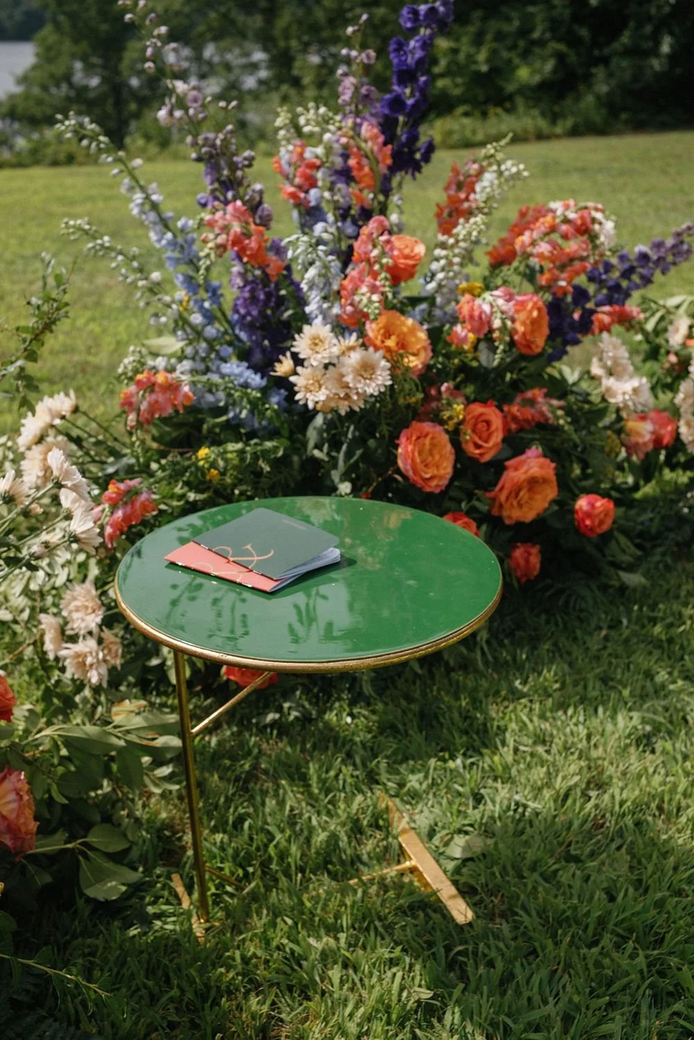 green-ceremony-table-plant-stand-with-vow-books-and-vibrant-flowers.jpg