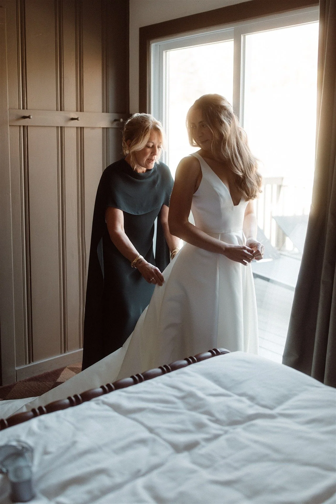 Mother-Of-The-Bride-Helping-The-Bride-Get-Into-Her-Dress-On-Her-Wedding-Day