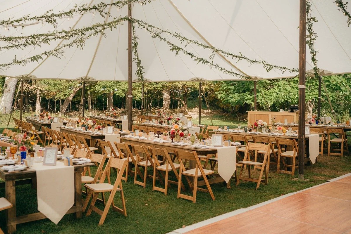 hudson-valley-ny-sailcloth-tent-wedding-with-greenery-garland-strung-from-ceiling-with-bistro-market-lights.jpg