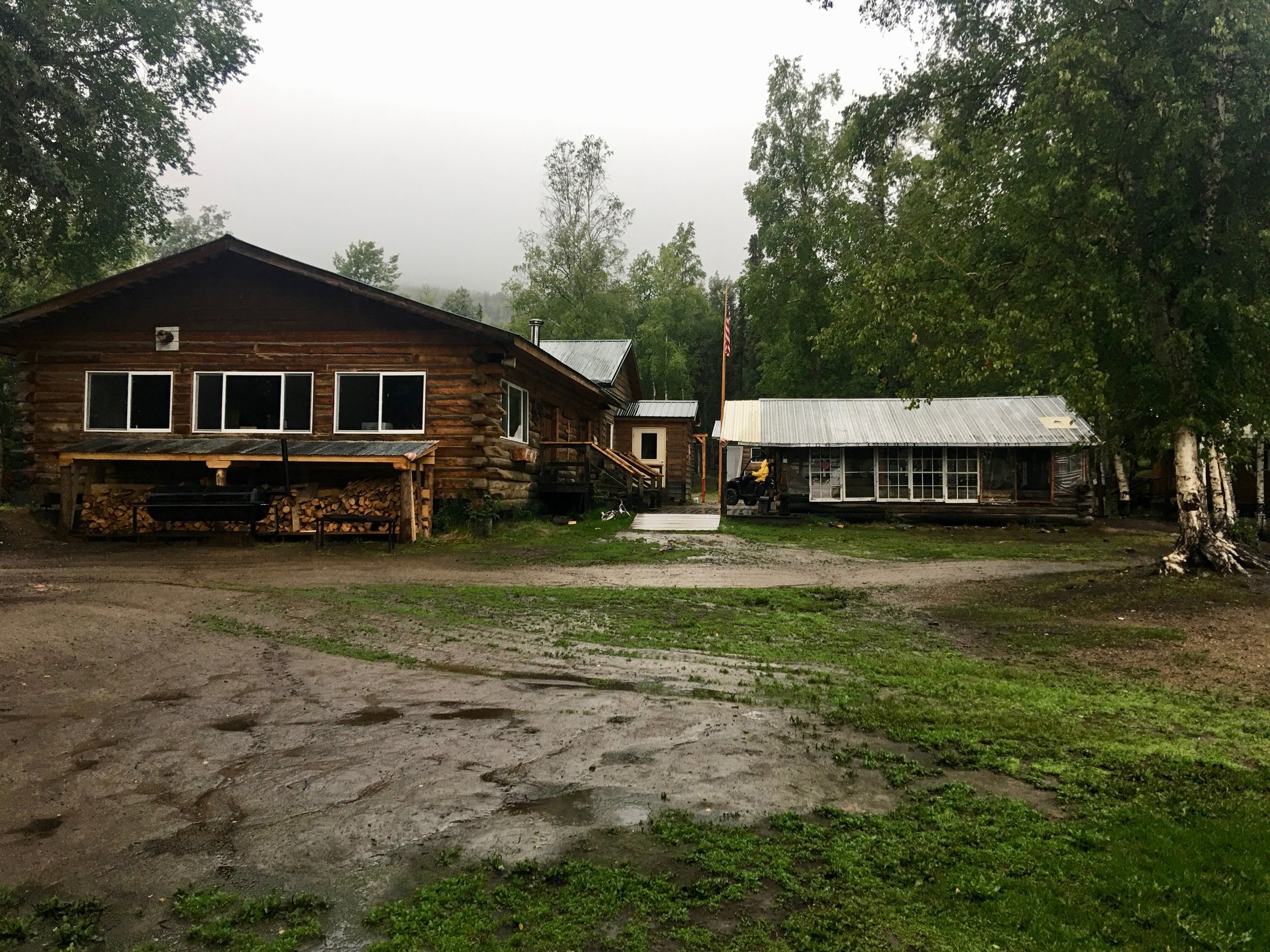 The main building. Inside the building was Shawn's wife, Nicole and their 4 children. They had just made donuts which were made with bear grease. On the stove was mooseburgers cooking and for an appetizer it was whitefish eggs. Shawn and Nicole were helping Carol and her husband Roger with the camp this summer. Shawn and Nicole with their children had been. living a subsitence lifestyle 90 miles up a neighboring river. They plan to return there next summer. It was a dry and warm evening as we listened to the rain hitting the roof. Nicole was glad to get some relief from the gnats, which were quite fierce this summer. We haven't experienced many bugs yet, but if the rain stops sounds like we will Sleeping in a dry cabin was not how we envisioned this day to unfold. We are feeling grateful as we fall asleep. Miles paddled 24 August 4 The rain had let up some so after a breakfast of cereal and homemade cinnamon rolls thanks to Nicole we packed up. A black bear had gotten into some of the fish that Shawn had been drying. The bear was hanging around the camp this morning and could not be scared off by shooting over it. We also learned that last night when a barge came to refill fuel at the camp, the bear had chased the workers back on to the barge. Apparently this has not been a good berry year and this bear had come down to the river in search of food. Unfortunately a bear with this type of aggressive behavior had to be shot. Shawn had learned that the large amounts of rain that had fallen was from a typhoon that had hit Japan. The weather forecast was calling for rain today, but not as much as the previous day. It was a very thankful good-by as we loaded our canoe and headed down the Yukon.