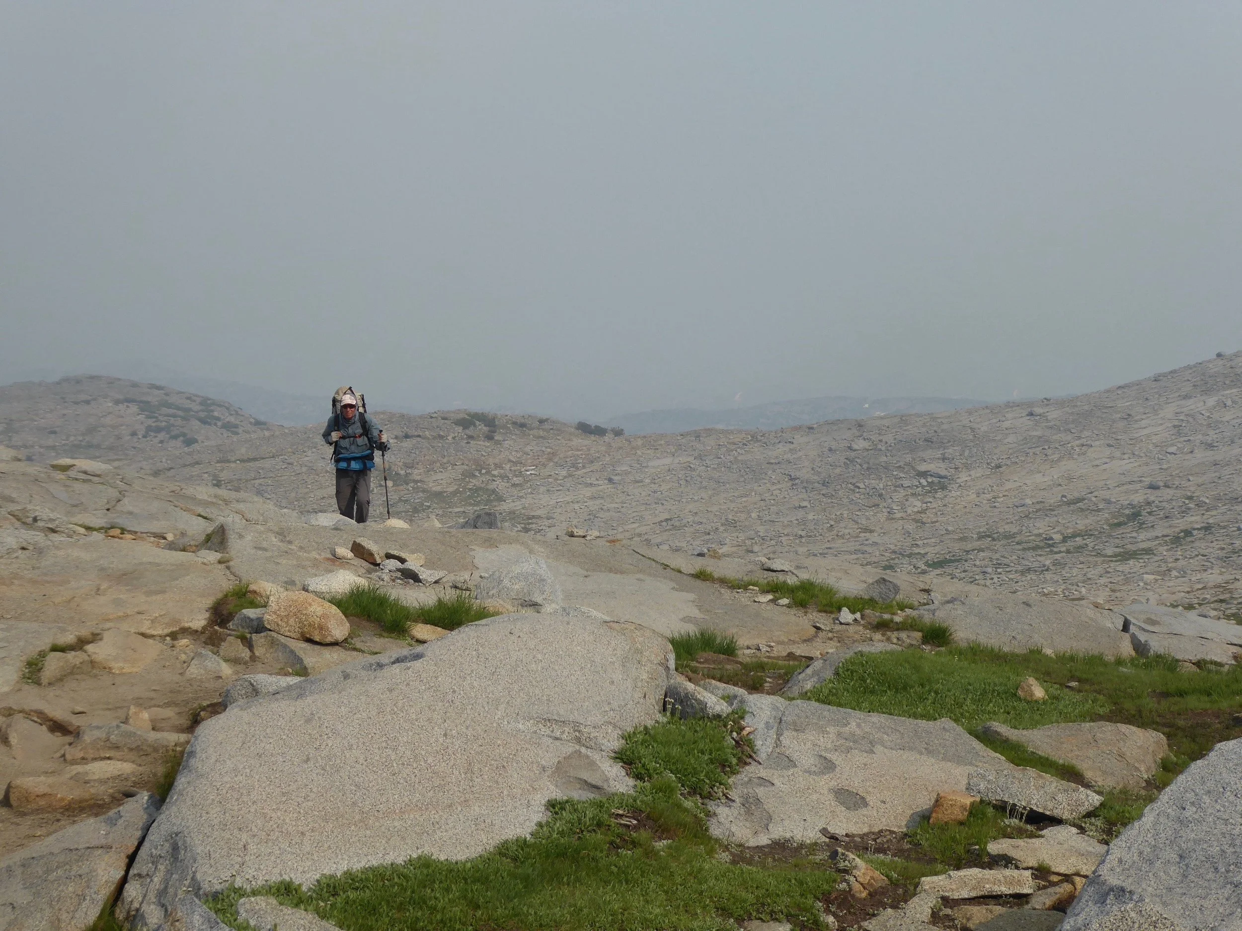 Heading up to the pass with clouds and smoke on the horizon.