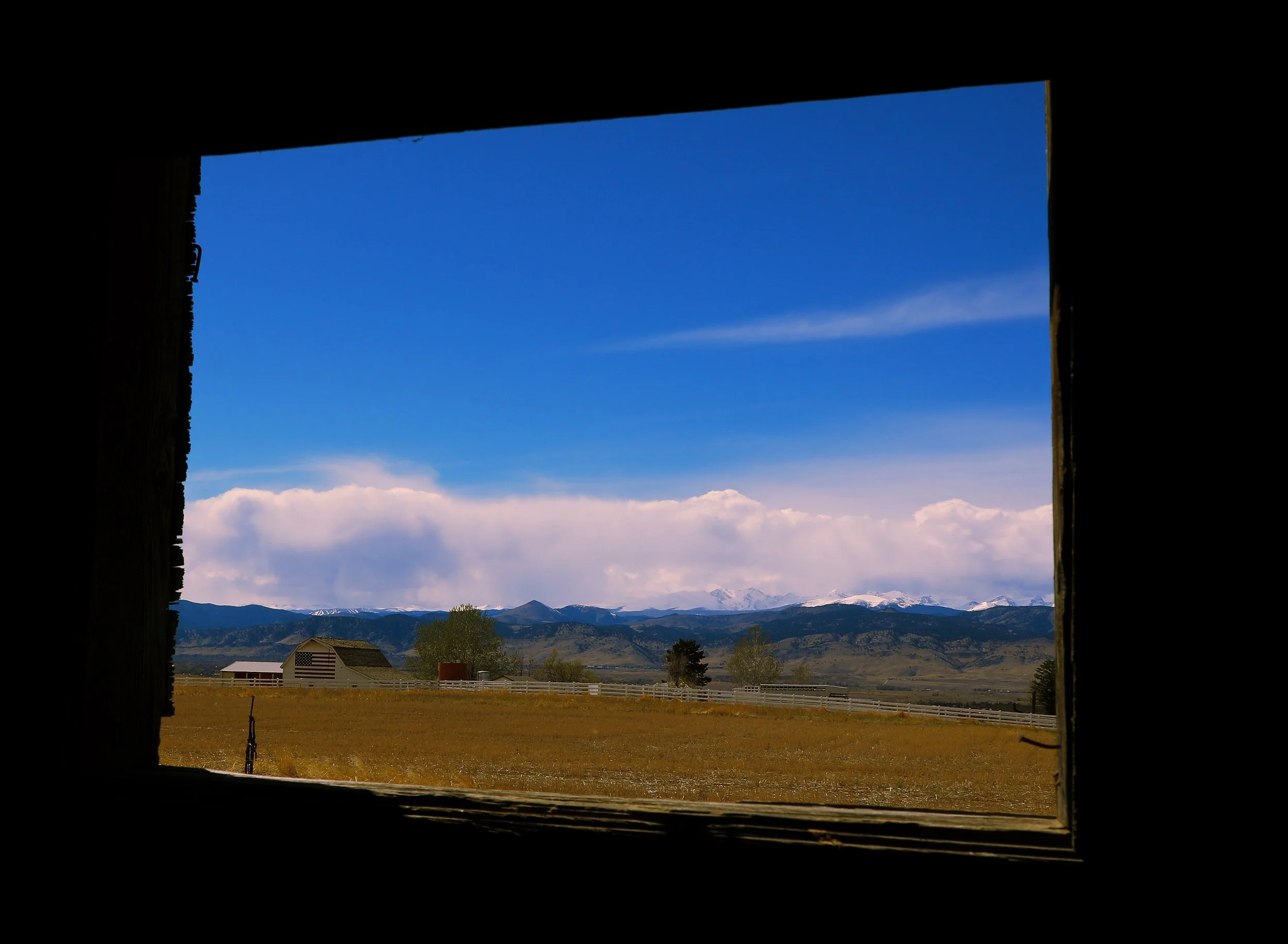 Flag Barn through the window of an abandoned cabin