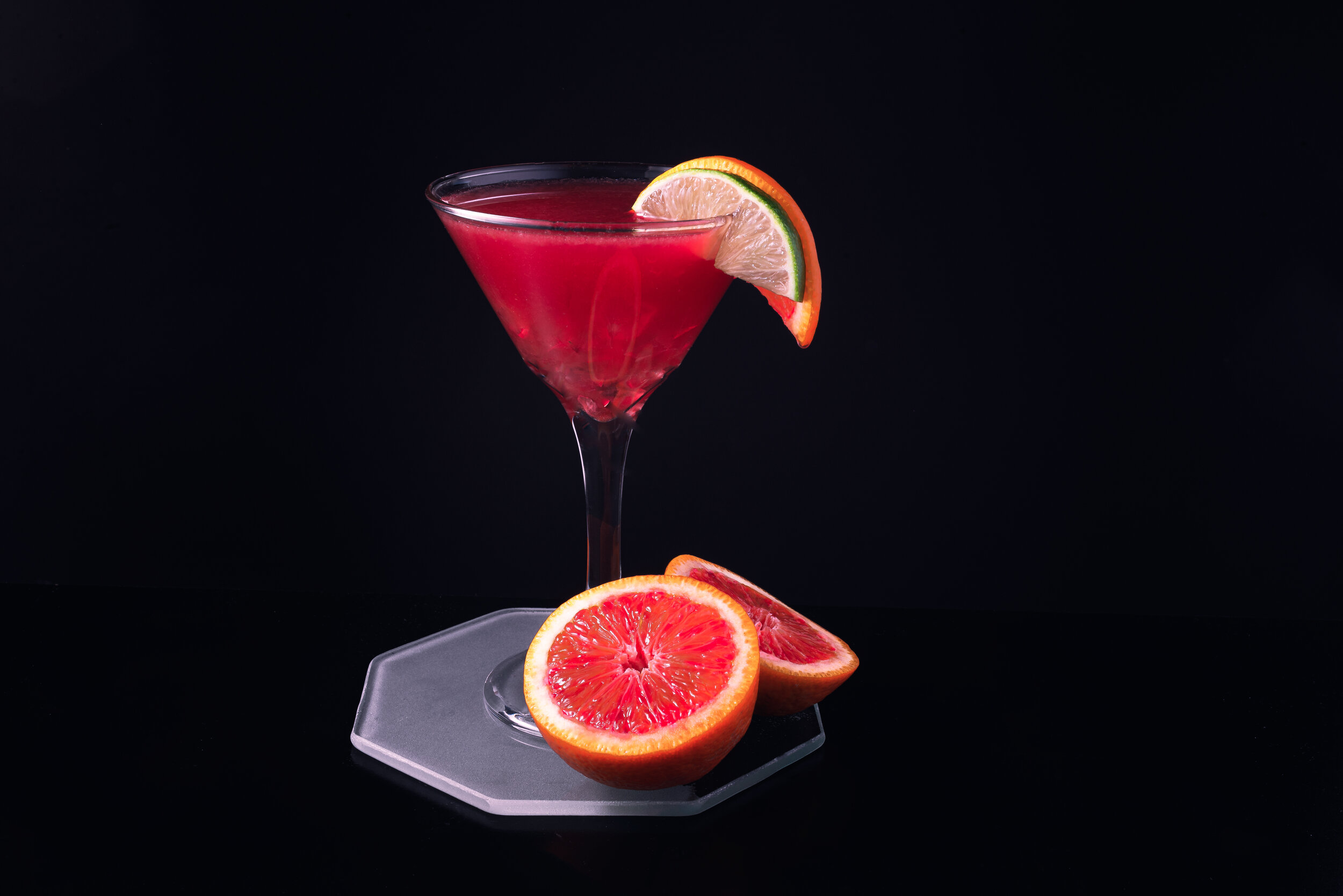 Blood orange martini on black background