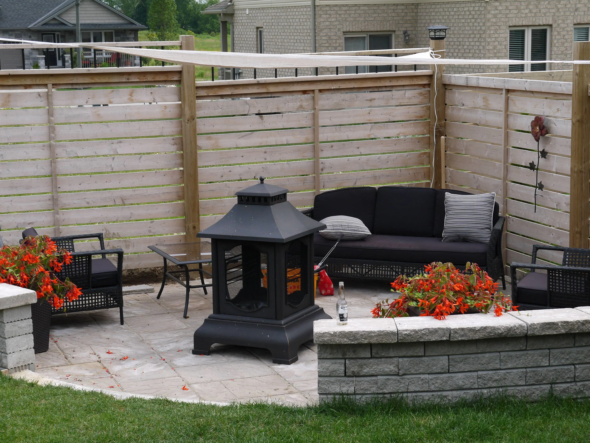 Custom stone patio with walls and coping by Fred's Fences