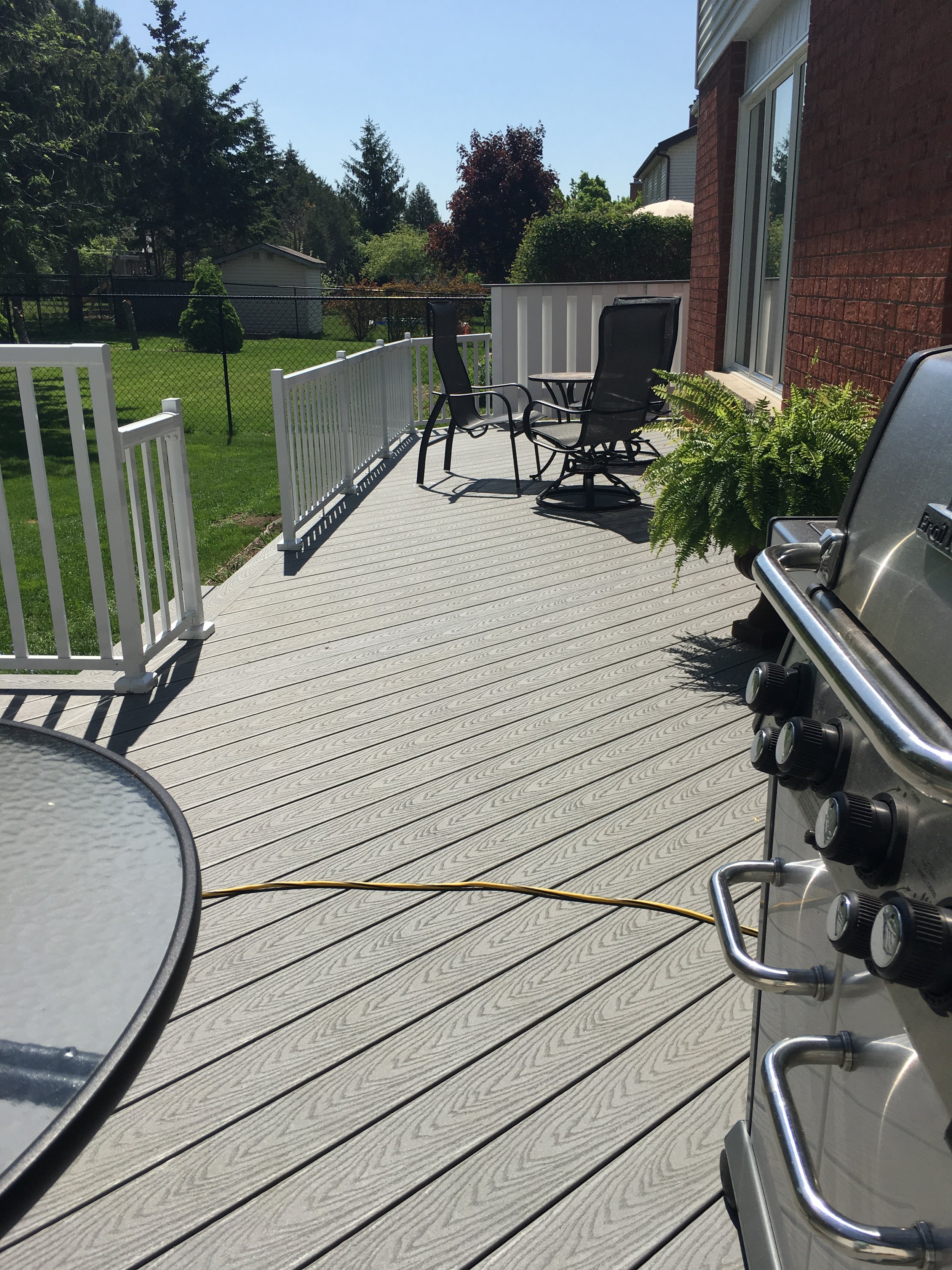 Trex decking diagonally placed on custom low-level deck, by Fred's Fences
