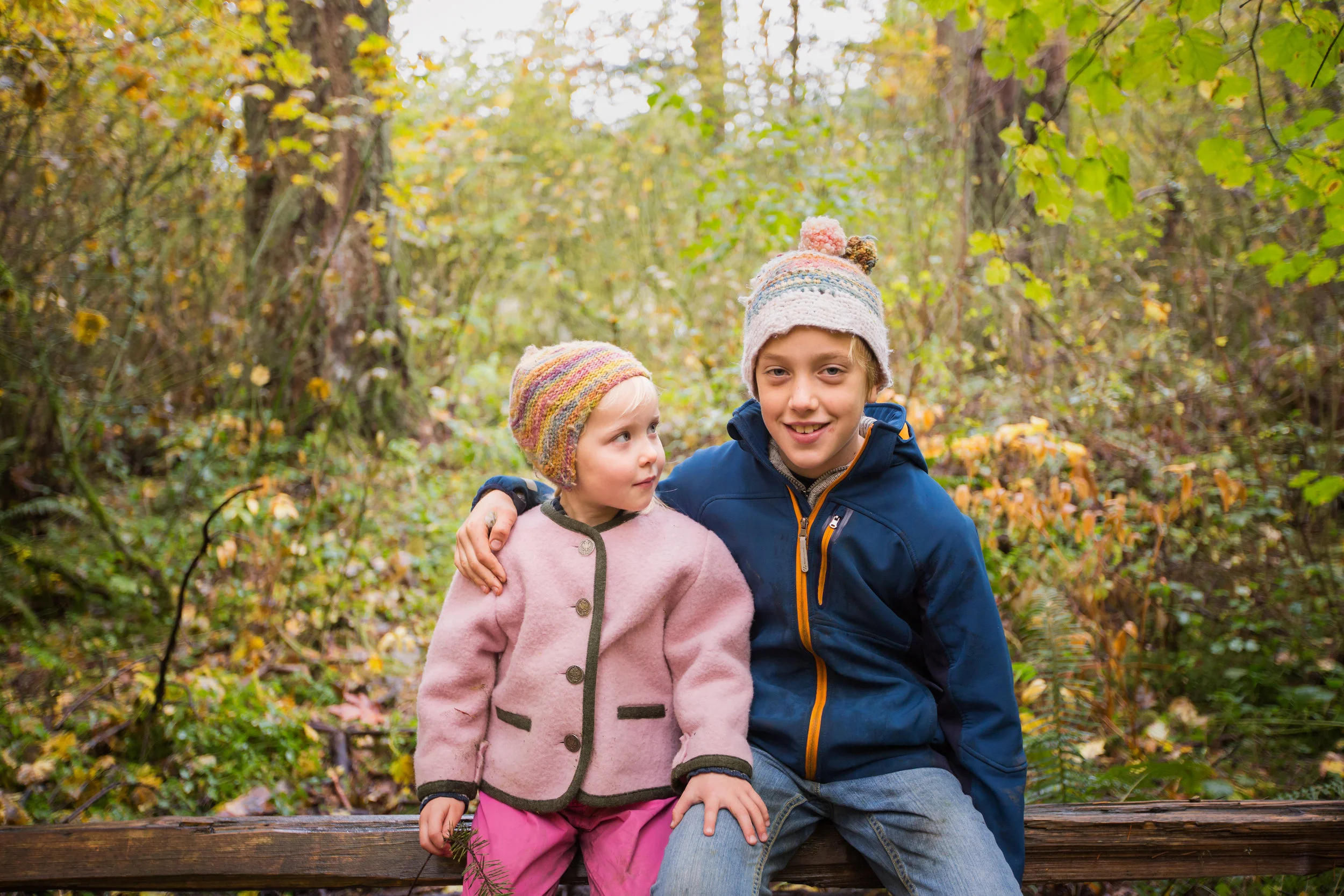 brother and sister sitting on fence